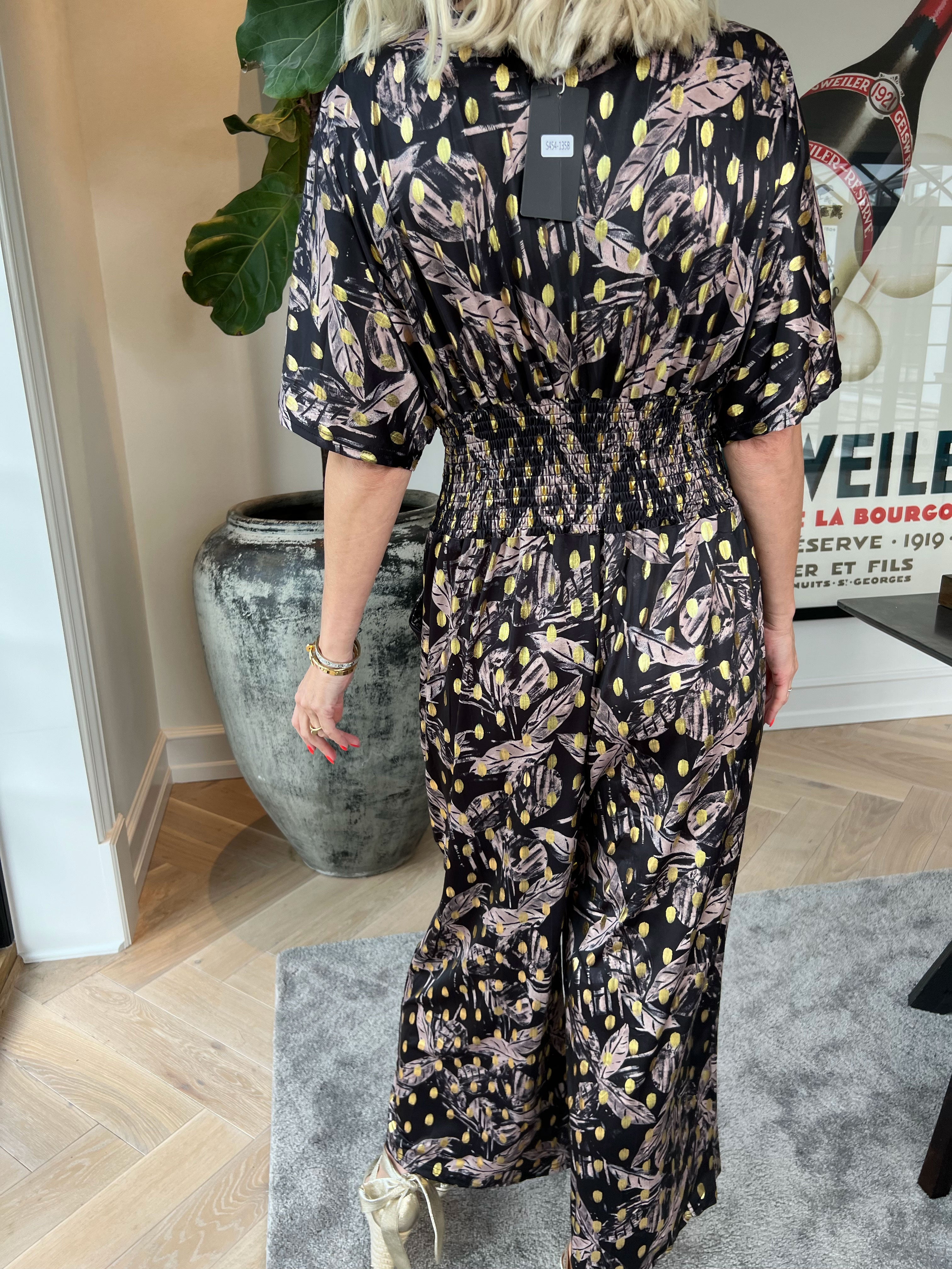Pams Leafage Jumpsuit - Elastisk jumpsuit i lövmönster med guldfärgade tofsar